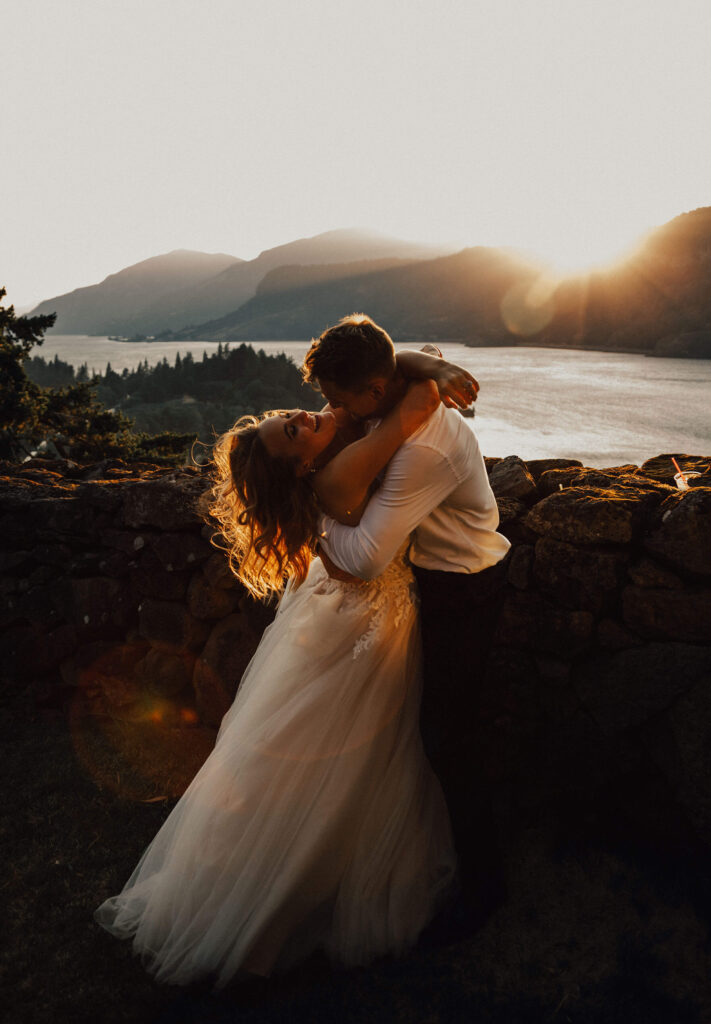 Oregon bride and groom hug at sunset overlooking the Columbia River Gorge at the Griffin House.