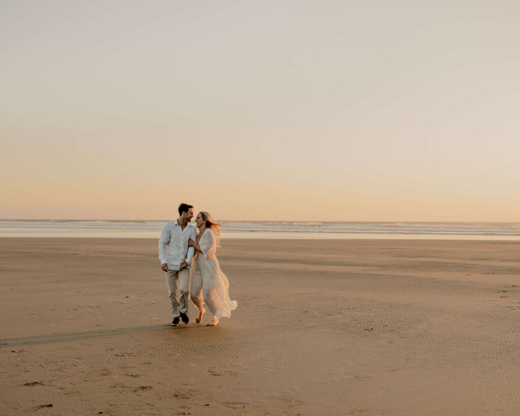 Couple walks on the beach for an oregon coast engagement session