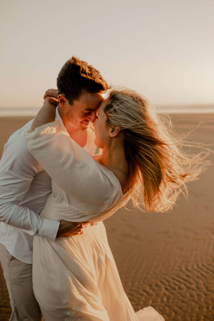 Couple dances on the beach for an oregon coast engagement session