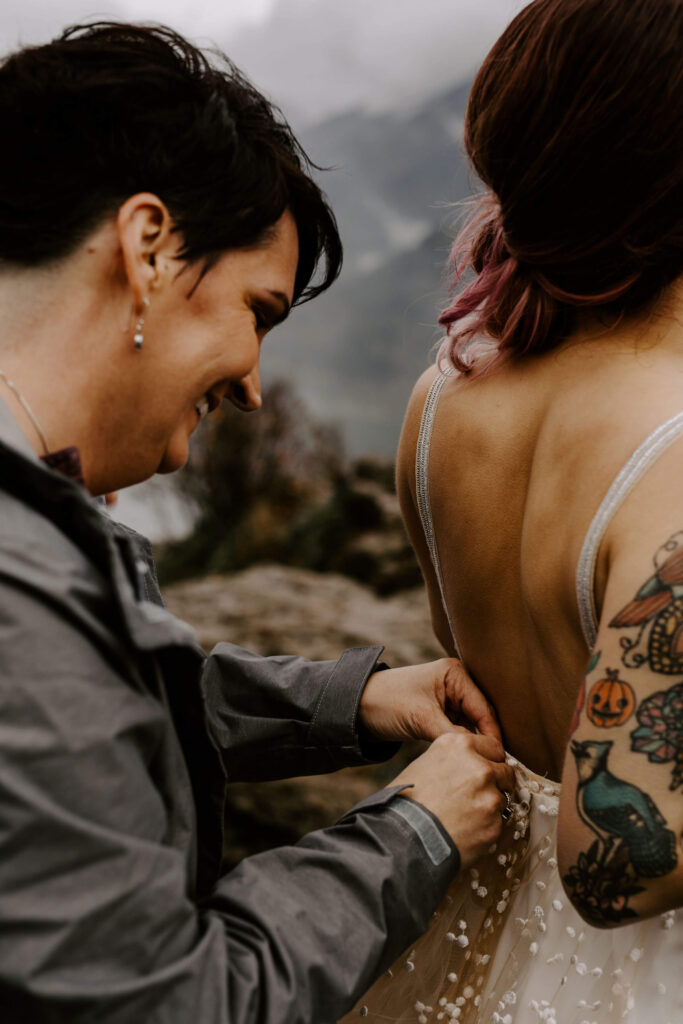 Mom fixes dress of a bride at a Washington Elopement on Rattlesnake Ledge