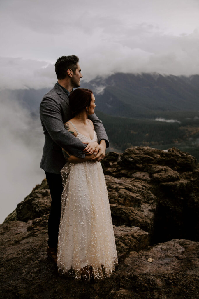 Couple looks out at the view at a Washington Elopement on Rattlesnake Ledge