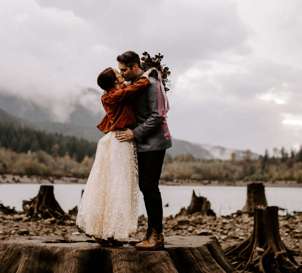 Couple kisses at the base of the hike at a Washington Elopement on Rattlesnake Ledge