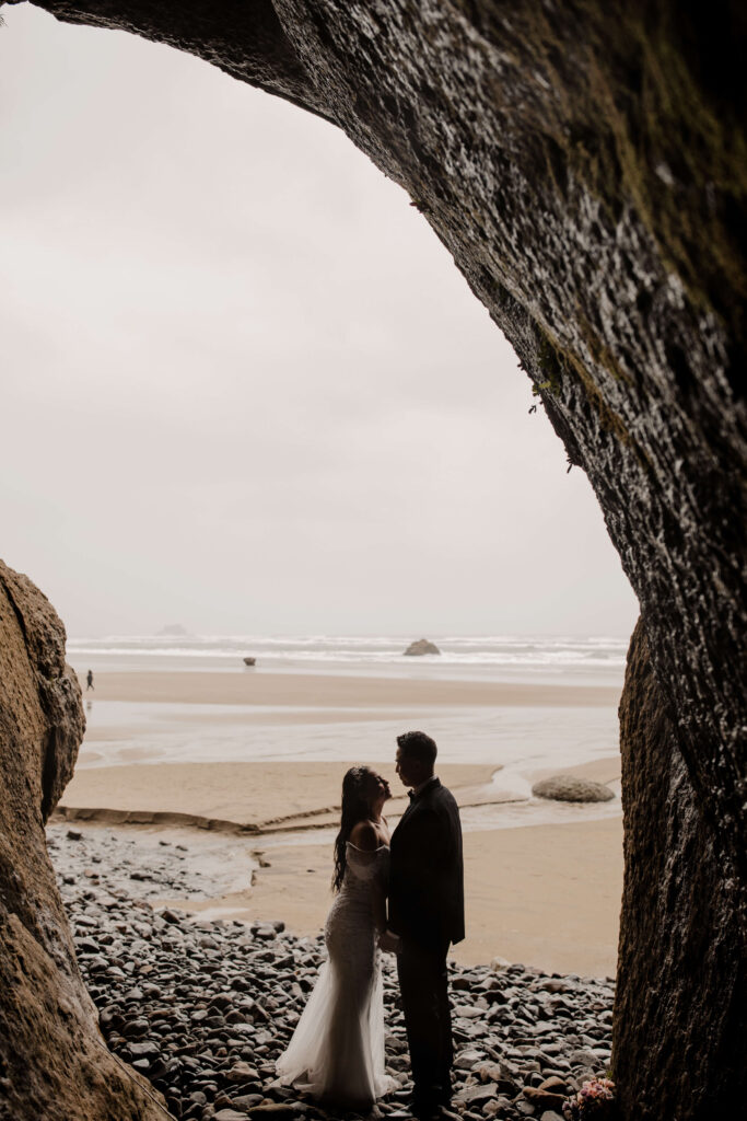 Couple embraces under a cave at their hug point oregon elopement