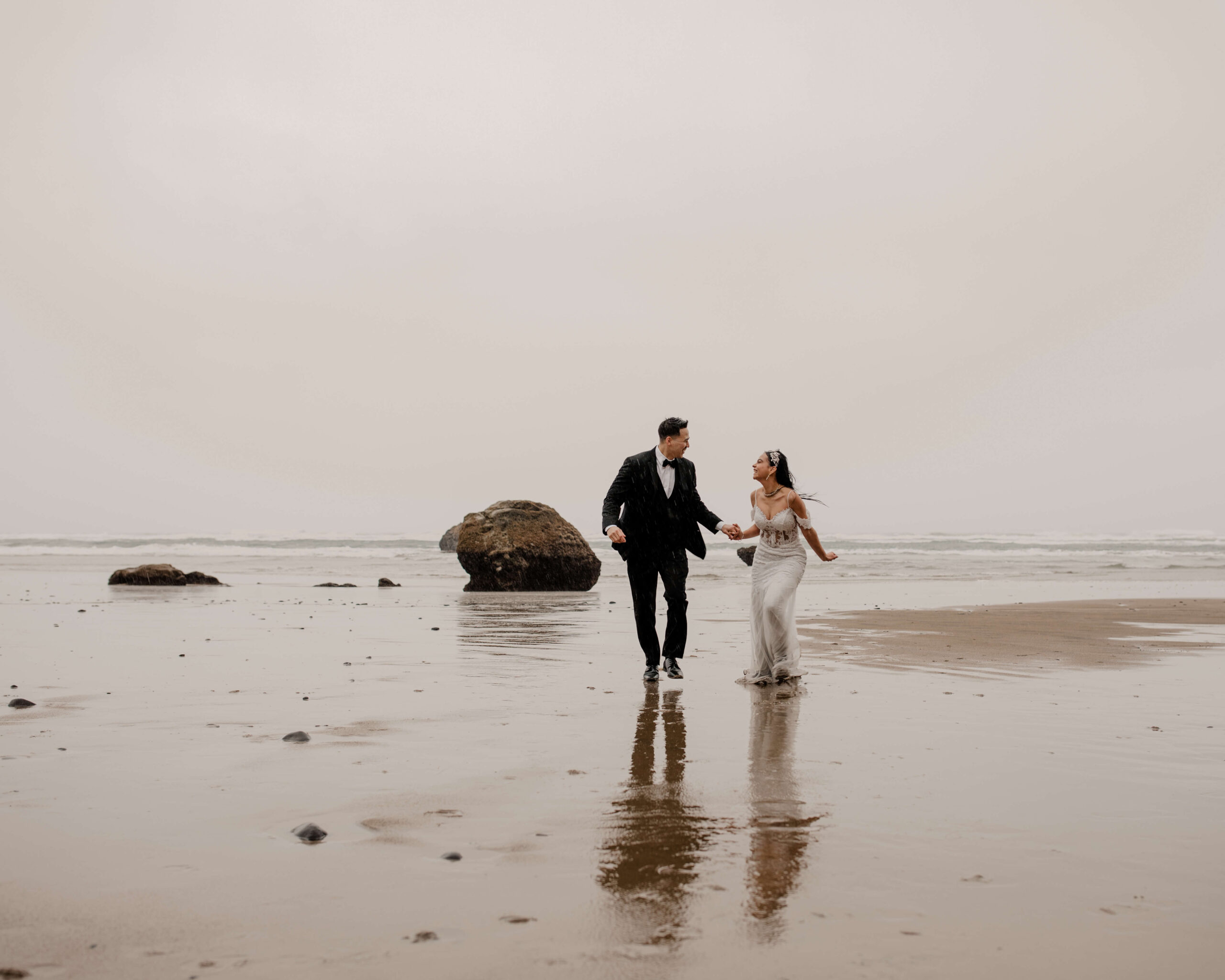 Couple runs on the beach at a Hug Point elopement
