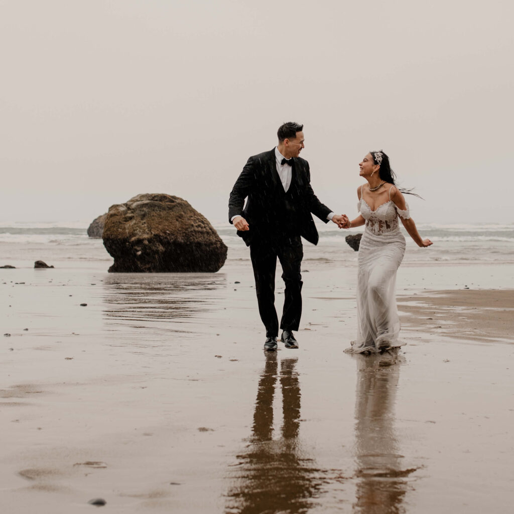 Couple runs on the beach at a Hug Point elopement