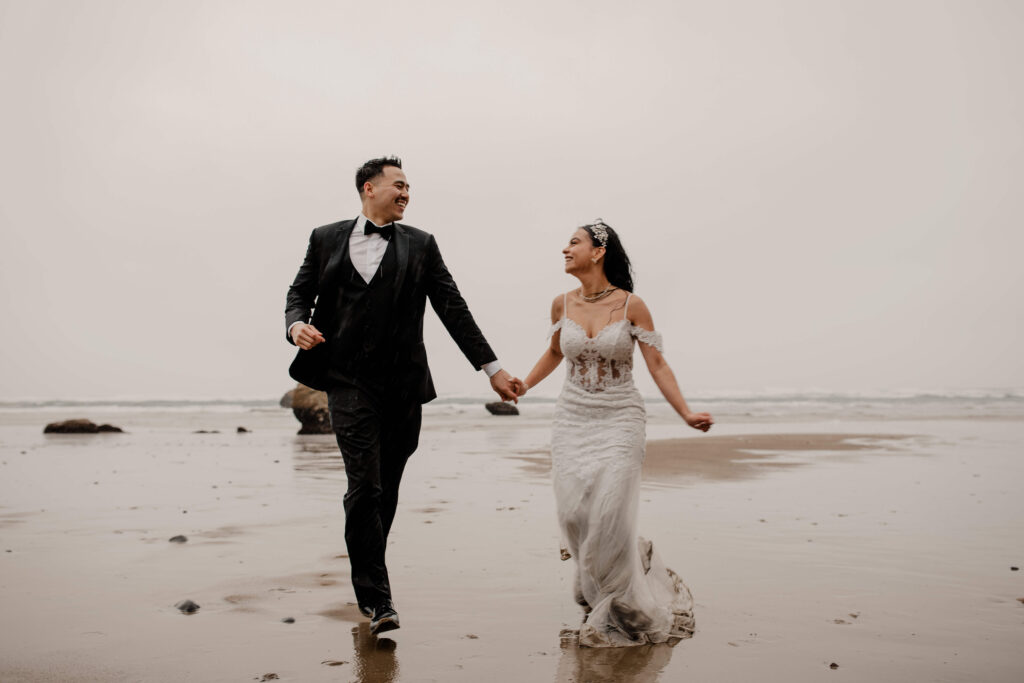 Couple runs on the beach at a Hug Point elopement