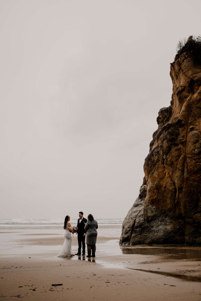 Couple exchanges vows at an elopement ceremony on the beach at Hug point in Oregon