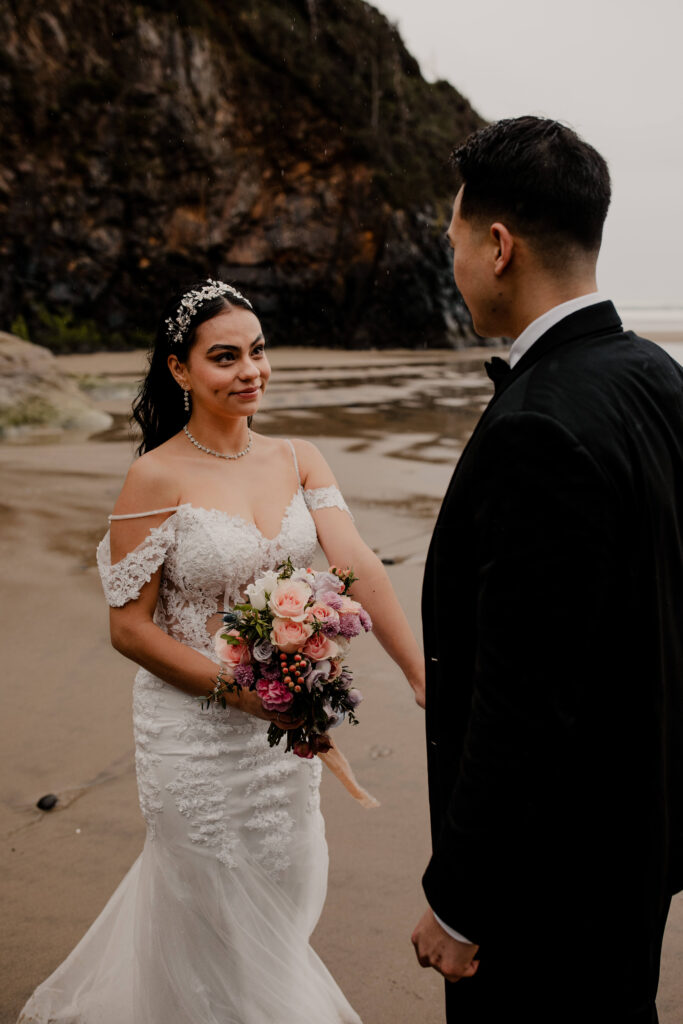 Couple exchanges vows at an elopement ceremony on the beach at Hug point in Oregon