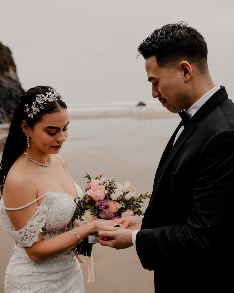 Couple exchanges rings while eloping on the beach at Hug point in Oregon