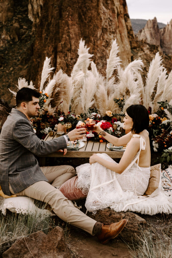 Couple toasts after a smith rock elopement with a small intimate picnic