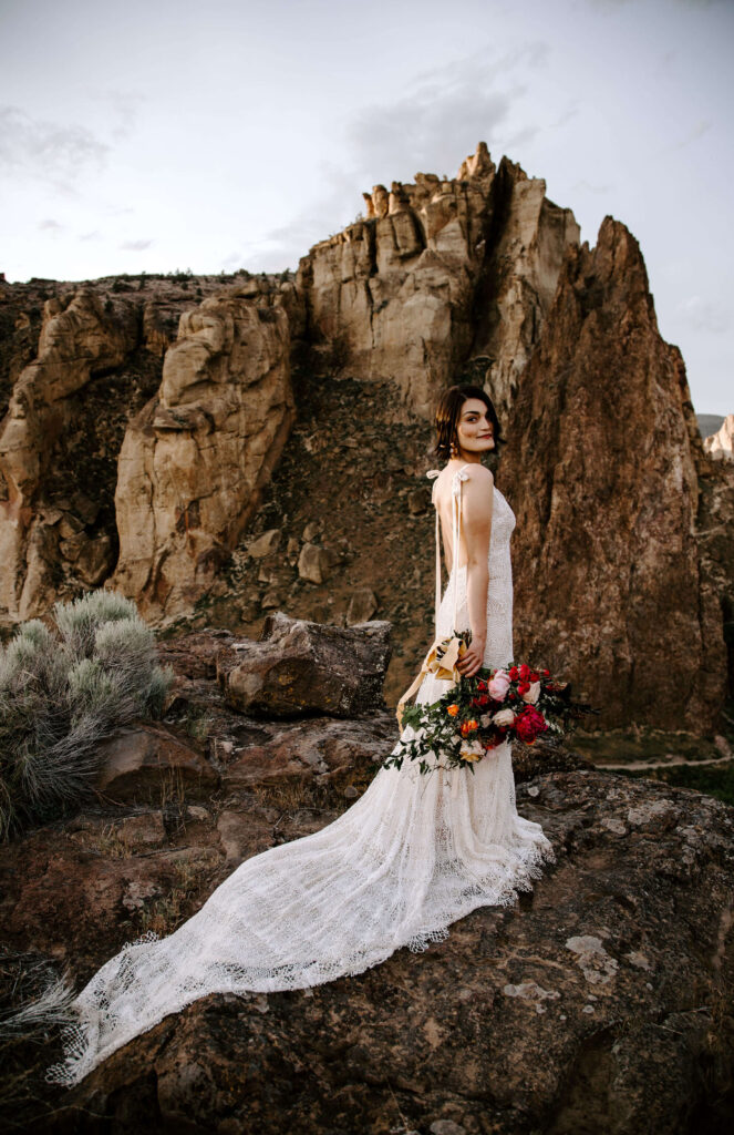 Bride poses in front of a cliff at Smith Rock Oregon