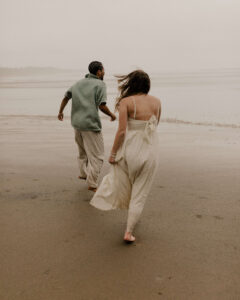 Couple runs on the beach at an Oregon coast engagement session shot by Ronny and Rene.