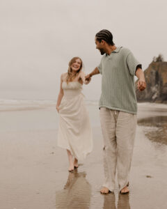 Couple runs on the beach at an Oregon coast engagement session shot by Ronny and Rene.