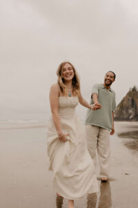 Couple runs on the beach at an Oregon coast engagement session shot by Ronny and Rene.