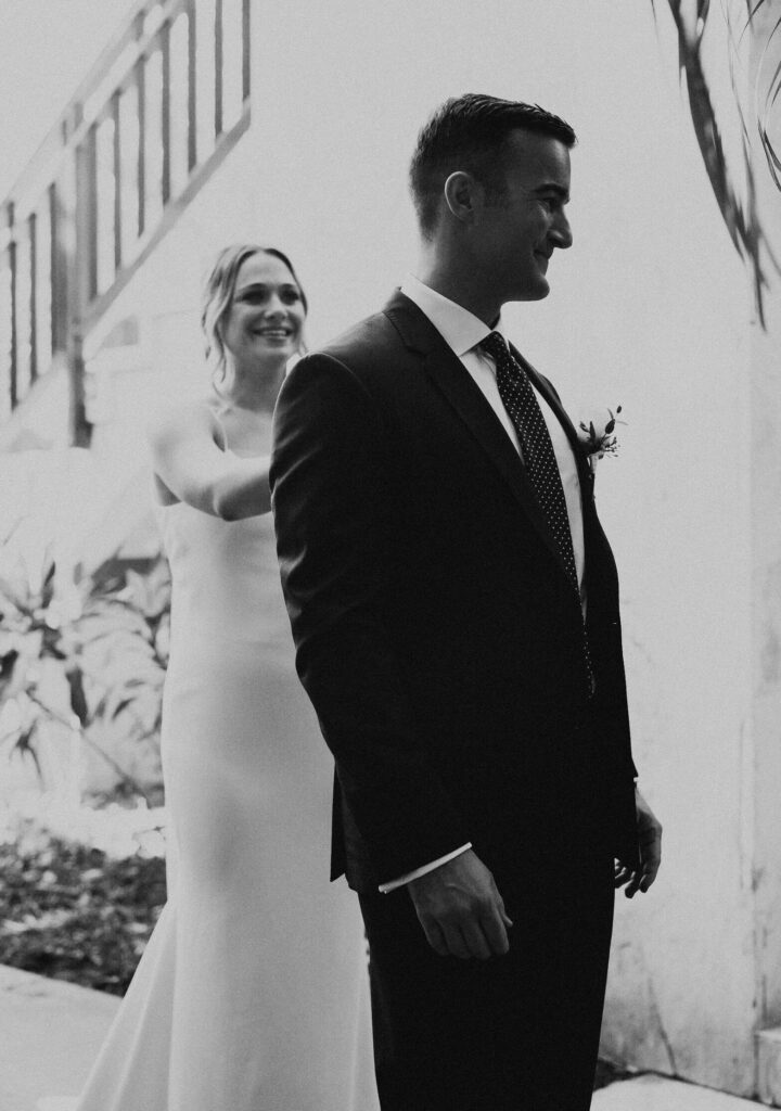 Groom waits to see his bride at their first look before their wedding