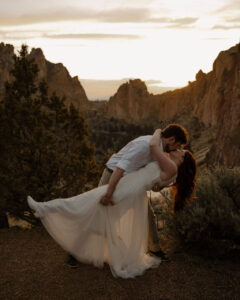 husband dips and kisses his wife at smith rock elopement photoshoot