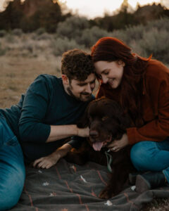 couple cuddling dog at smith rock engagement photoshoot