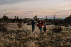 couple running with dog at smith rock engagement photoshoot