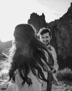 couple spinning each other around in circles at smith rock engagement photoshoot