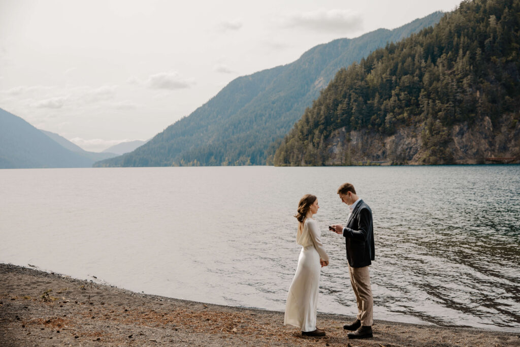 couple saying vows in front of lake at olympic national park