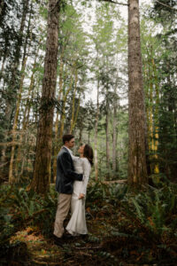 wedding couple looking in each others eyes in olympic national park forest