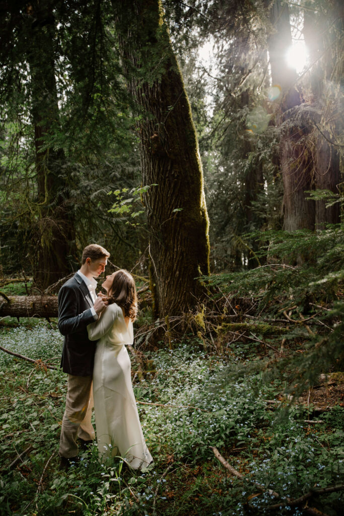elopement couple look in each others eyes in olympic national park forest