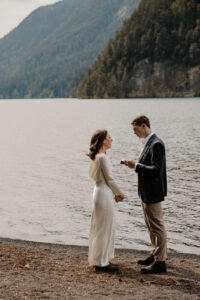 couple saying vows in front of lake at olympic national park