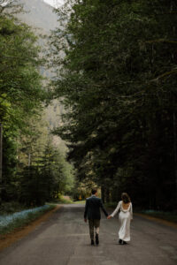 elopement couple holding hands down road at olympic national park