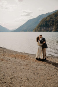 wedding couple kissing in front of lake at olympic national park