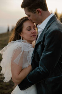 closeup of elopement couple, groom kissing bride's forehead, olympic national park