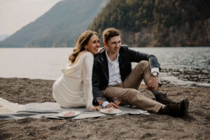 wedding couple posing in front of lake at olympic national park