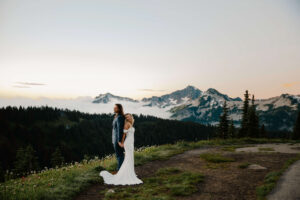 bride and groom back to back with beautiful mount rainier landscape behind them after elopement