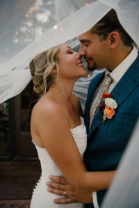 couple kissing under bride's veil for elopement at mount rainier