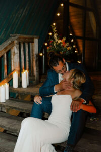 Couple kissing on cabin staircase at nighttime with candlelight at mount rainier