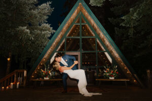 Groom dips Bride in front of Cabin at Mount Rainier Elopement Ceremony