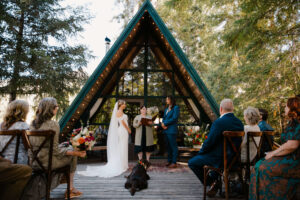 dog lays in wedding aisle as couple reads vows