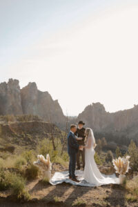 Couple exchanging vows with mountain peaks in the distance.