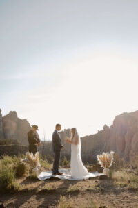 Couple exchanging vows with mountain peaks in the distance.