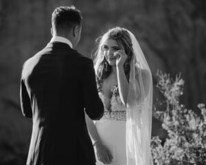 Black and white photo of bride smiling during vows.