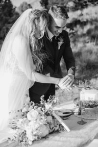 Wedding couple cuts cake pieces at smith rock state park