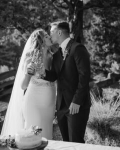 Wedding Couple kiss while cheering with champagne flutes at smith rock state park