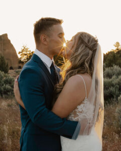 Bride and groom kiss along a trail at Smith Rock during golden hour