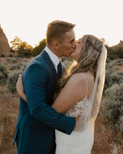 Bride and groom kiss along a trail at Smith Rock.