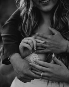 Black-and-white close-up of hands showing wedding rings at Smith Rock.