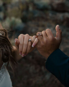 Close-up of bride and groom exchanging rings at Smith Rock.