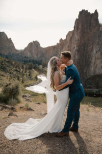 Couple kissing near rocky cliff ledge overlooking Smith Rock.