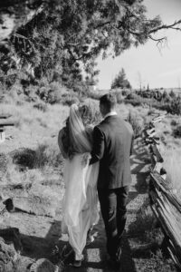 Bride and groom walk hand in hand along Smith Rock trail.