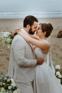 Couple exchanges a kiss on the oregon coast at their vow renewal