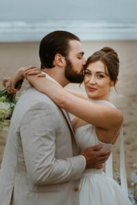 Couple exchanges a kiss on the oregon coast at their vow renewal