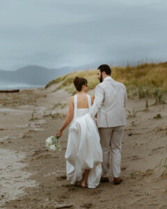 Couple walks by the ocean at their oregon coast vow renewal
